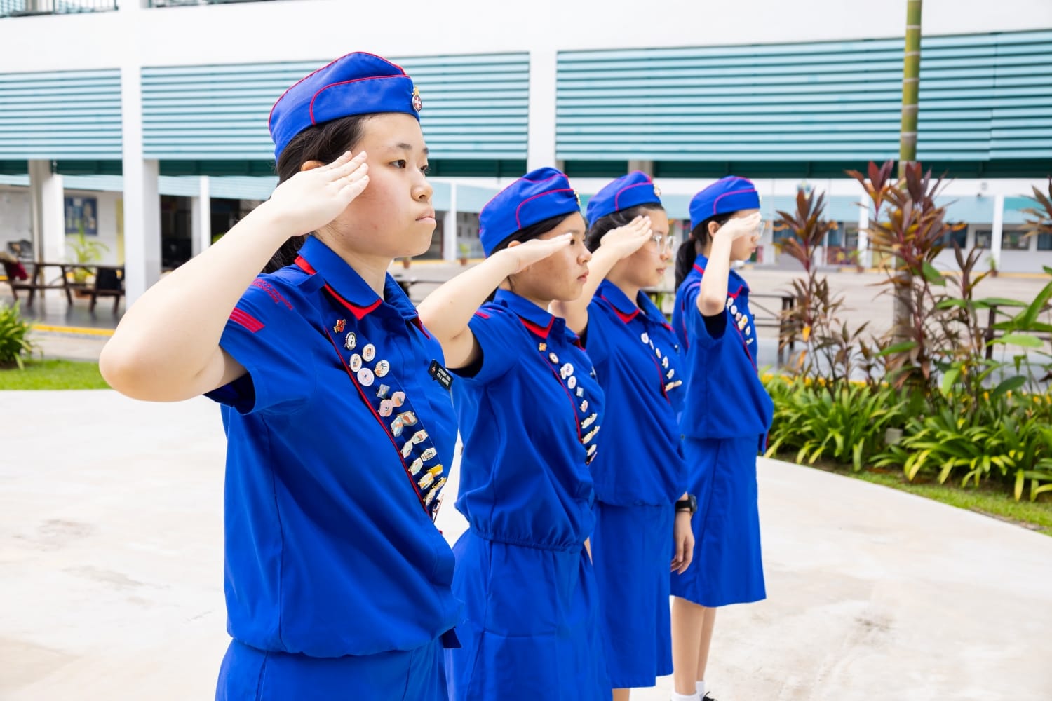 a group of 4 girls in girls brigade uniform saluting